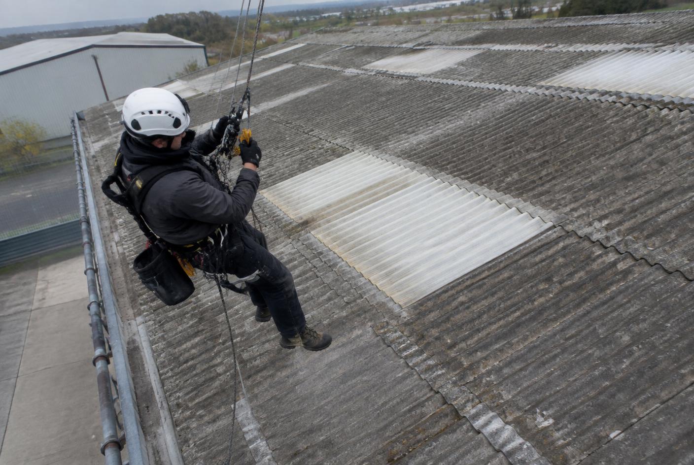 Technician using rope access to safely reach a fragile industrial roof area