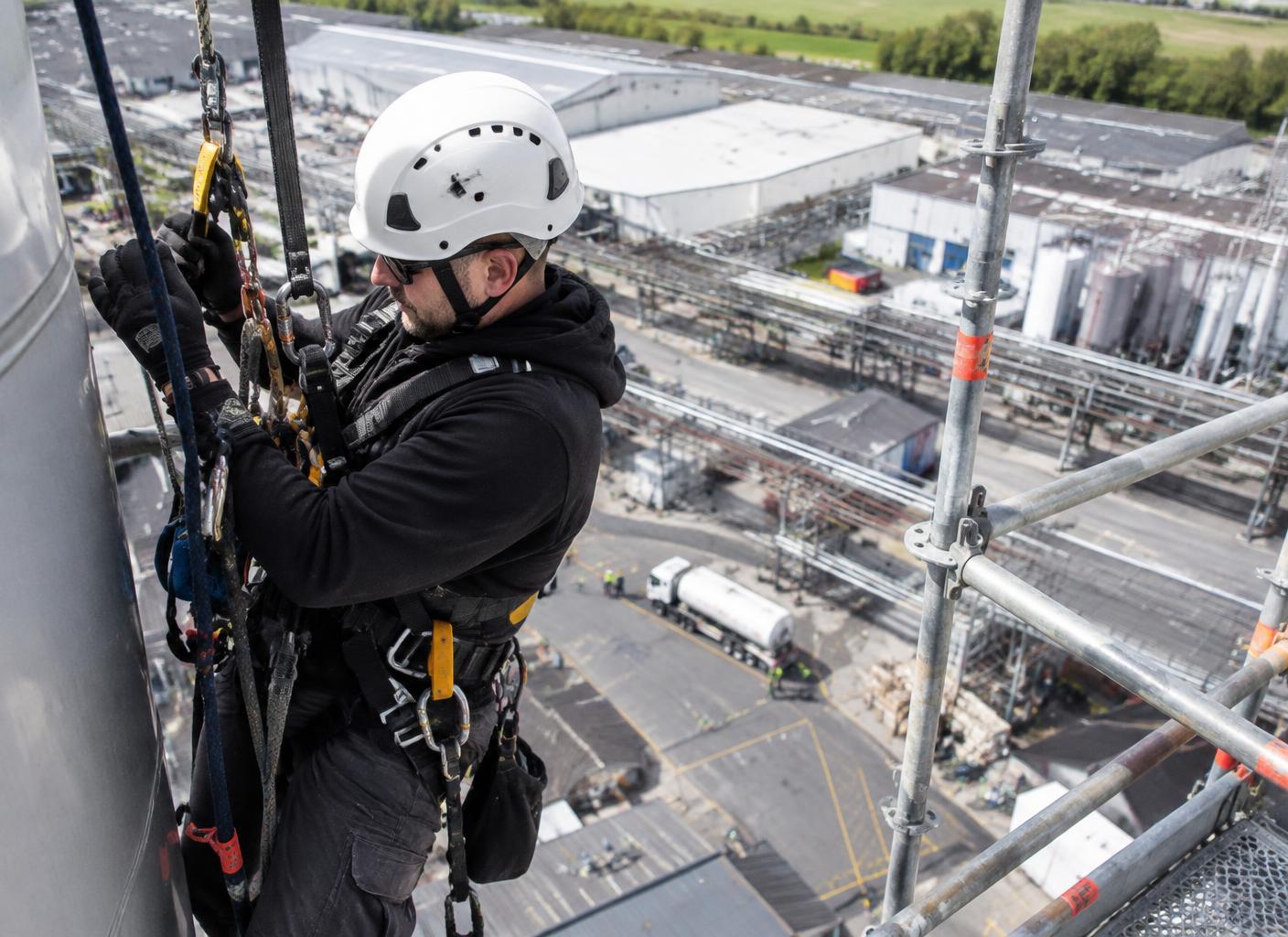 Rope access supporting a live-site industrial roof replacement alongside scaffolding