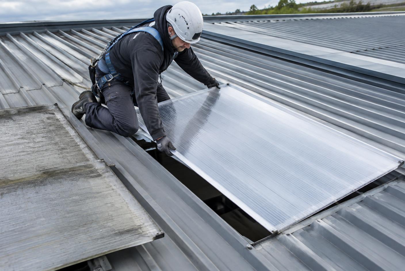 Technician replacing a rooflight during an industrial roof refurbishment
