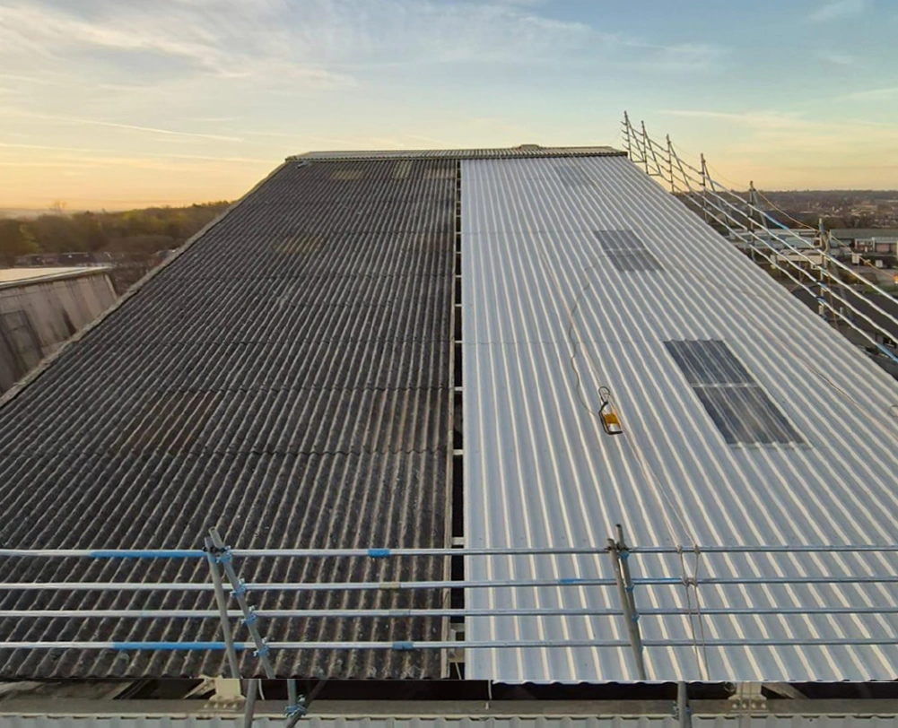 Industrial silo head house roof mid-installation with new white sheeting replacing old panels